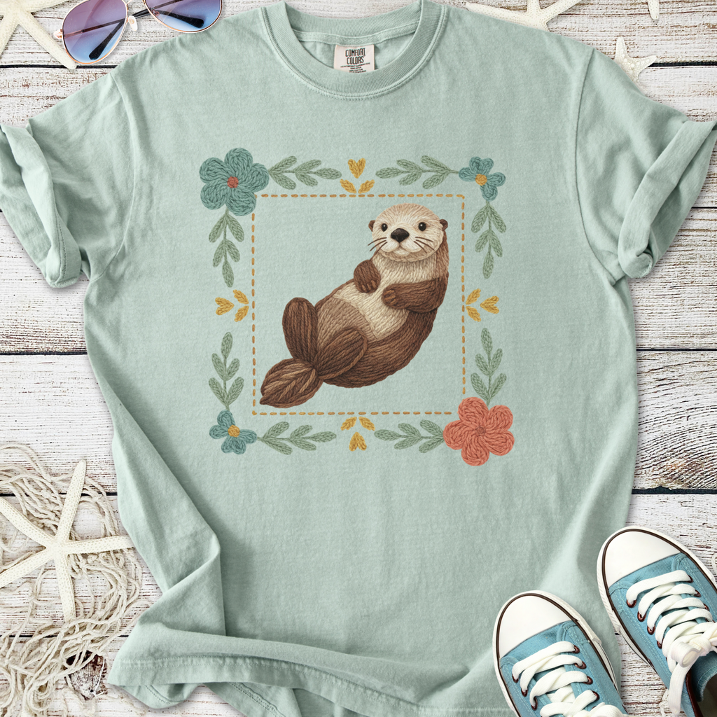 Mint green t-shirt featuring a cute otter graphic with floral design, made of soft cotton fabric.