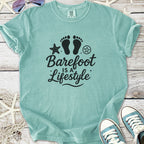 Mint green t-shirt with 'Barefoot is a Lifestyle' graphic, perfect for casual beachwear.