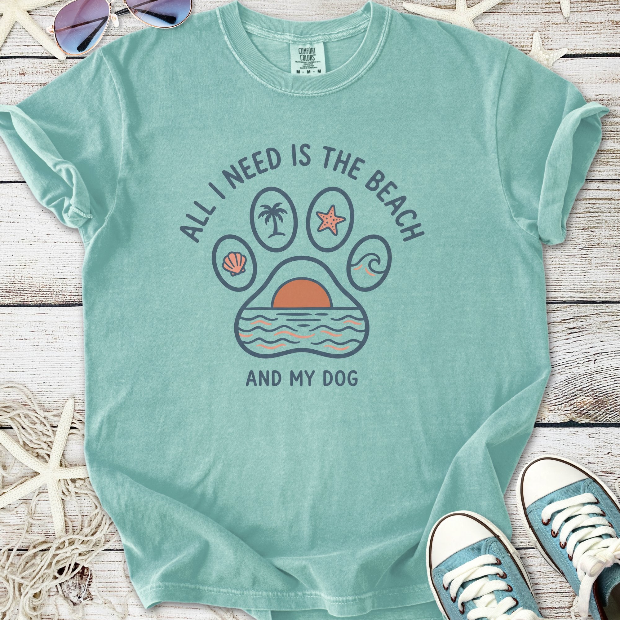 Teal graphic t-shirt with beach-themed paw print design saying 'All I Need Is The Beach And My Dog'