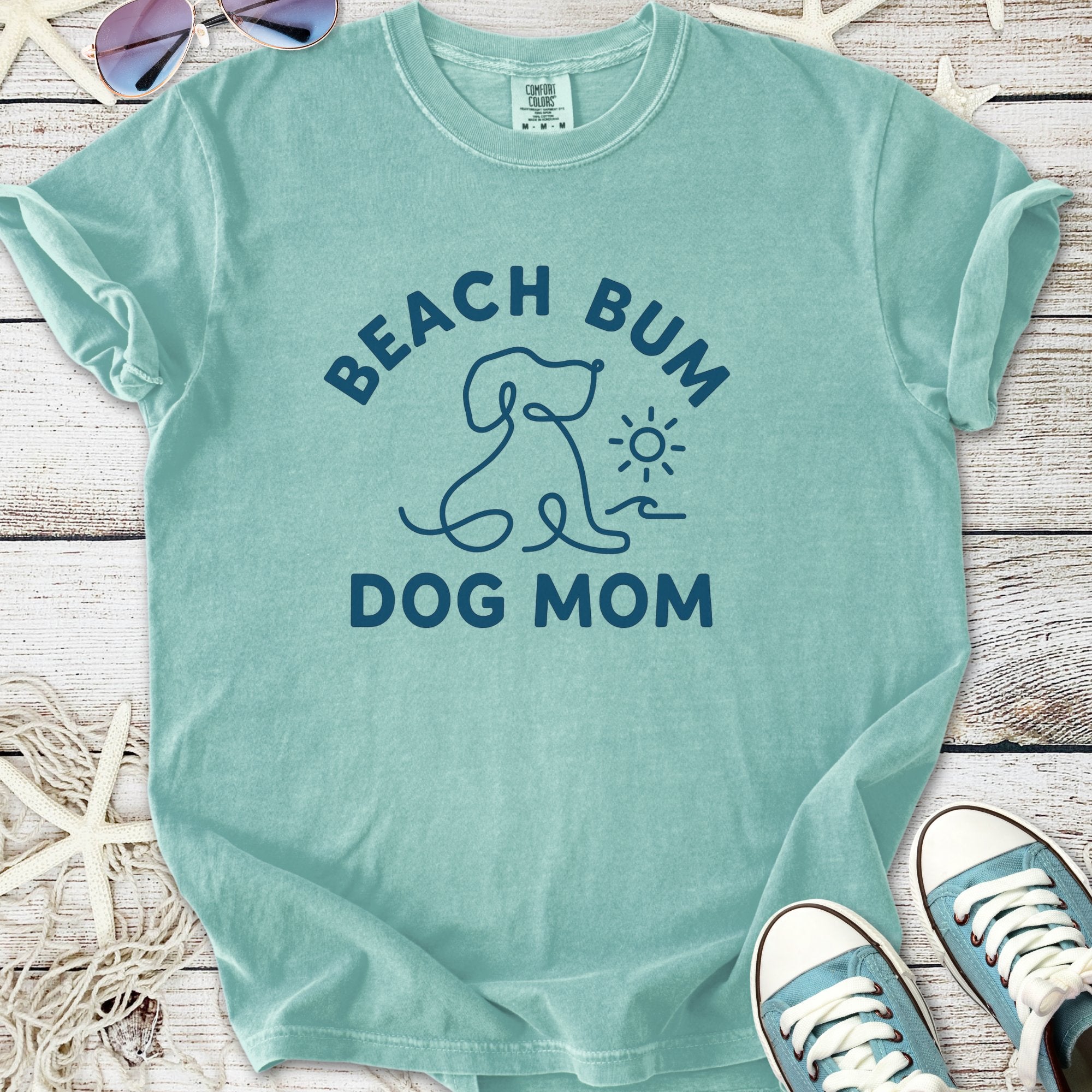 A teal cotton t-shirt featuring 'Beach Bum Dog Mom' graphic, ideal for pet lovers.