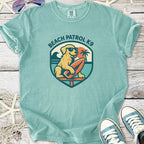 Light teal Beach Patrol K9 t-shirt featuring a surfing dog graphic, ideal for dog lovers and beach enthusiasts.