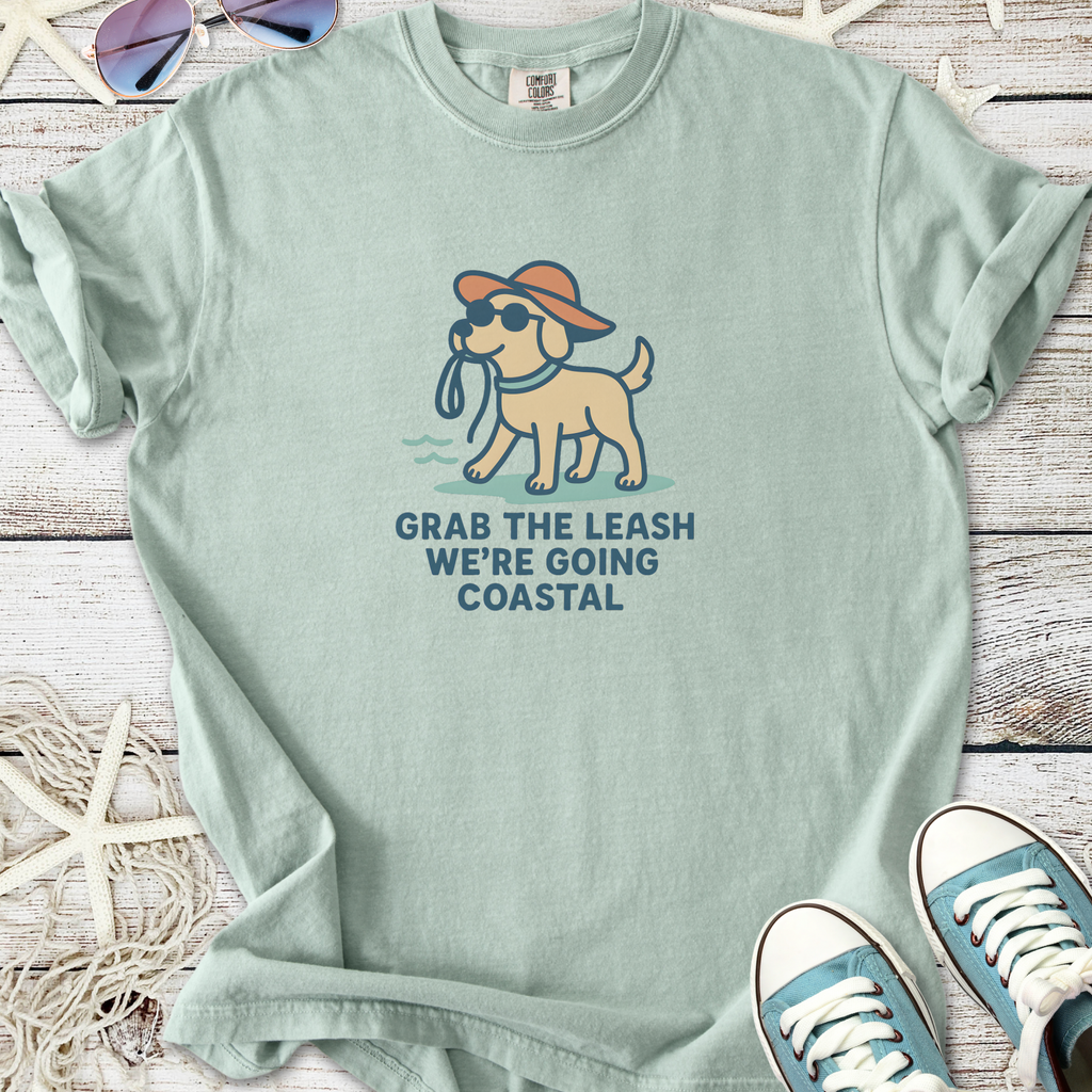 Mint green t-shirt featuring a playful dog graphic and the phrase 'Grab the leash, we’re going coastal'.
