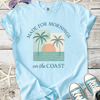 Light blue t-shirt with beach-themed print, featuring palm trees and sunset. Perfect for coastal mornings.