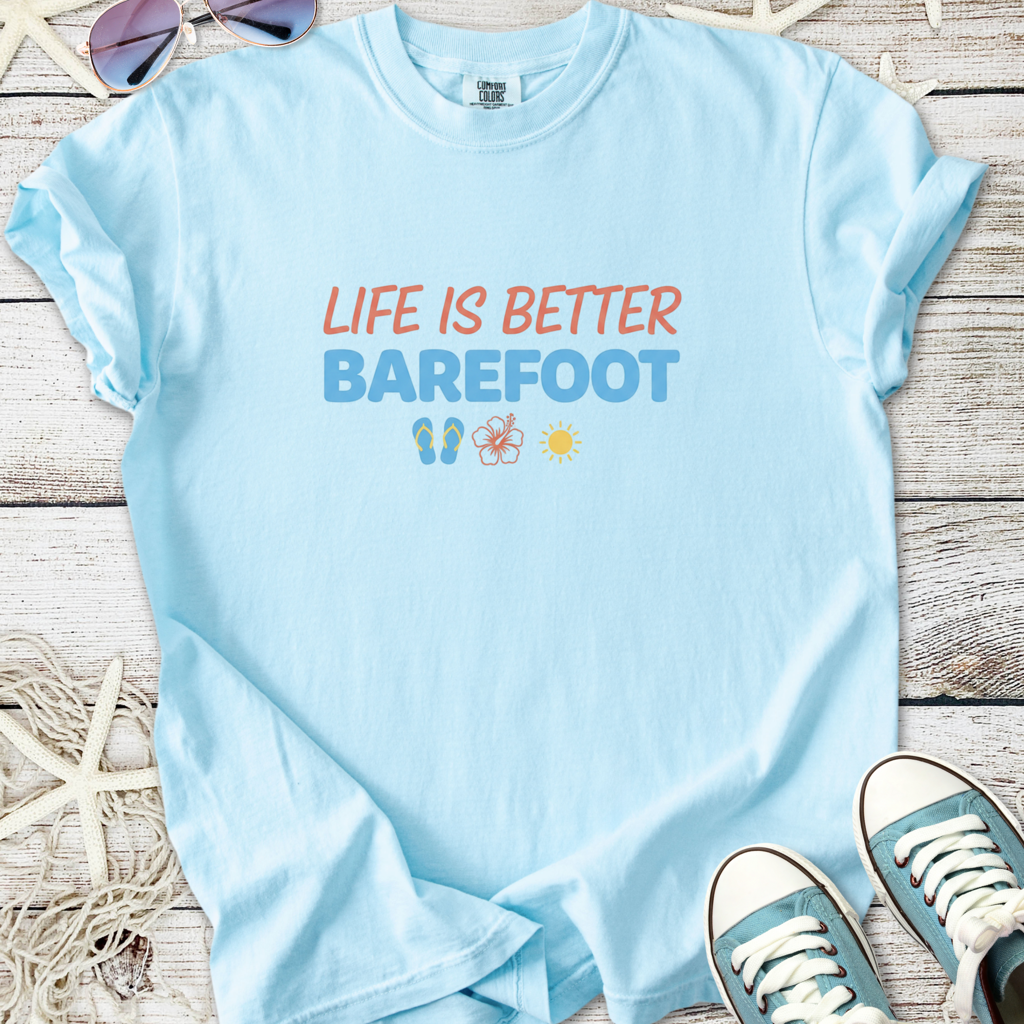 Light blue t-shirt with 'Life is Better Barefoot' graphic, made from soft cotton, perfect for casual wear.