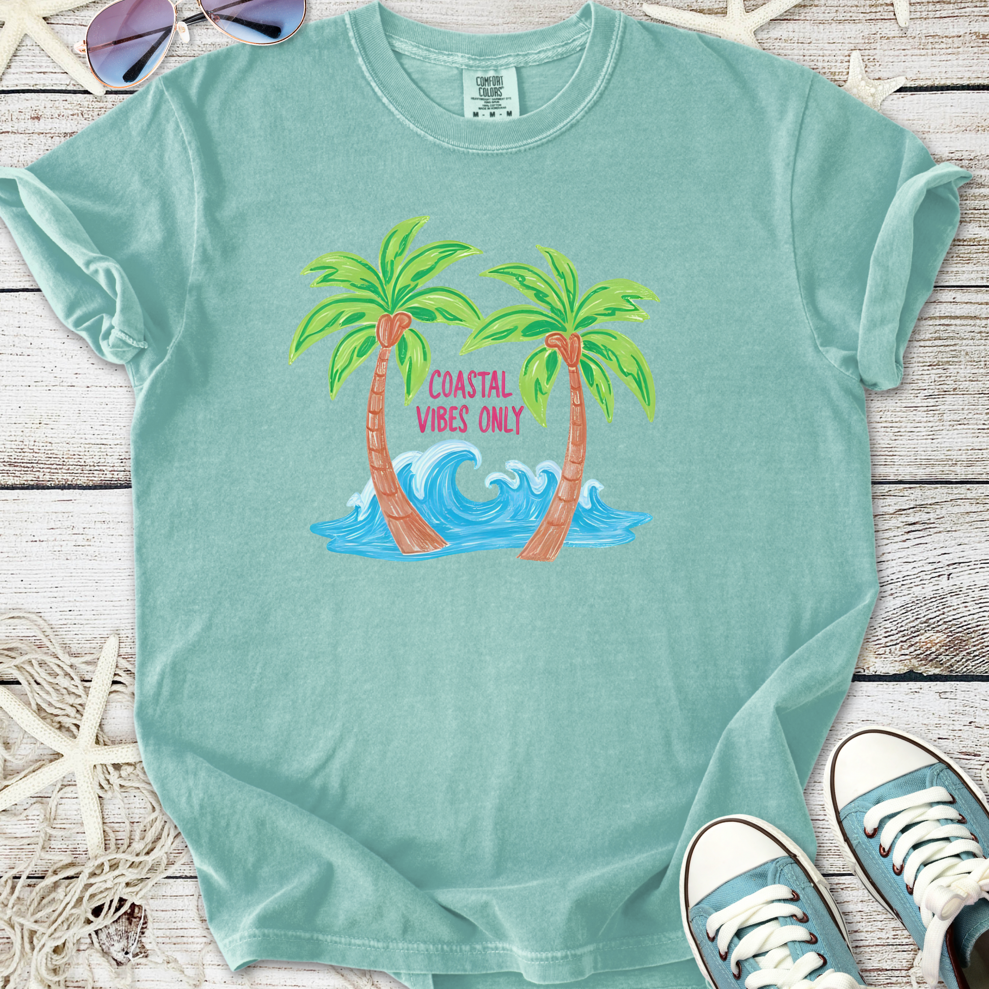 Teal graphic tee featuring palm trees and wave design, perfect for coastal vibes and casual wear.