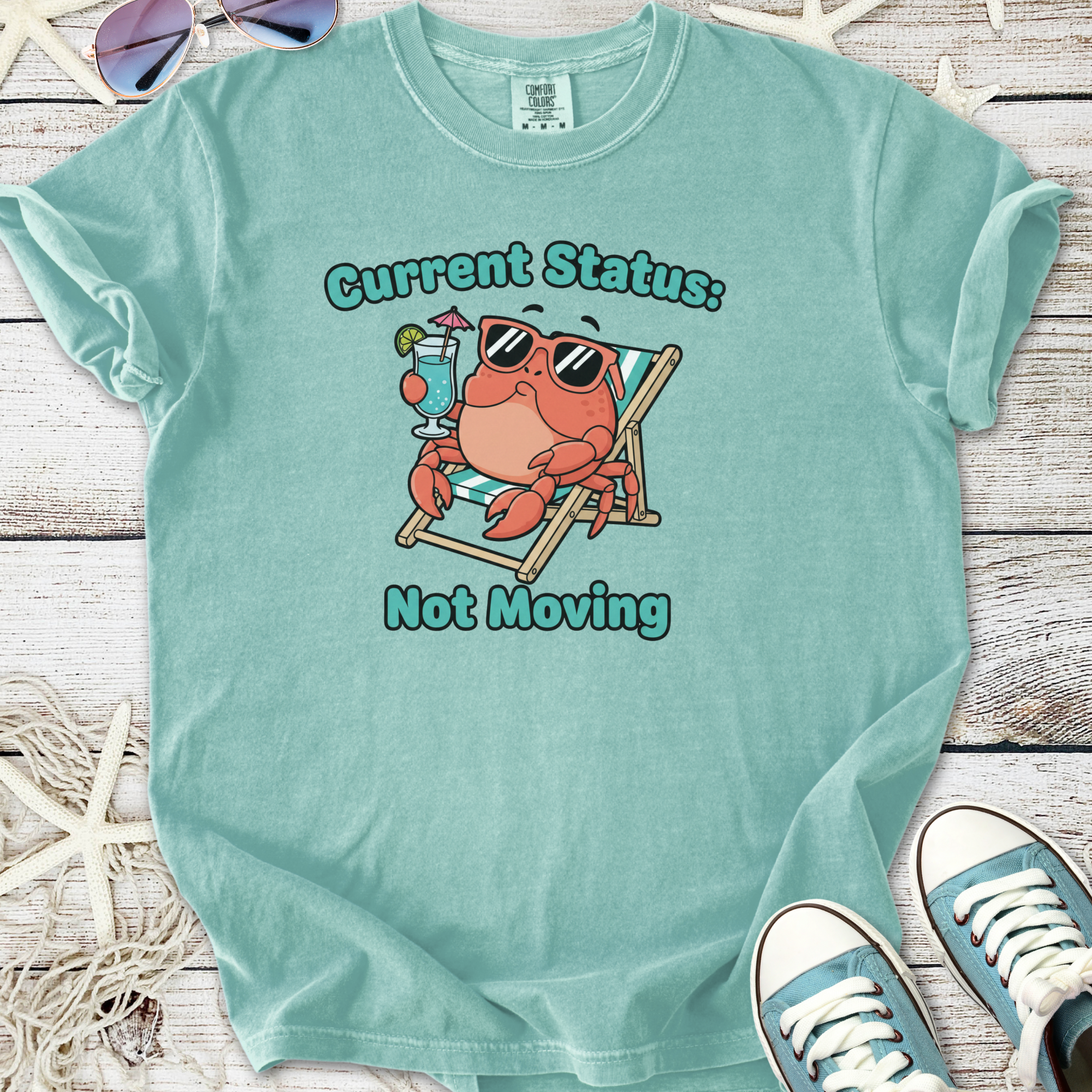 Light teal t-shirt with crab graphic and 'Current Status: Not Moving' text, perfect for summer lounging.