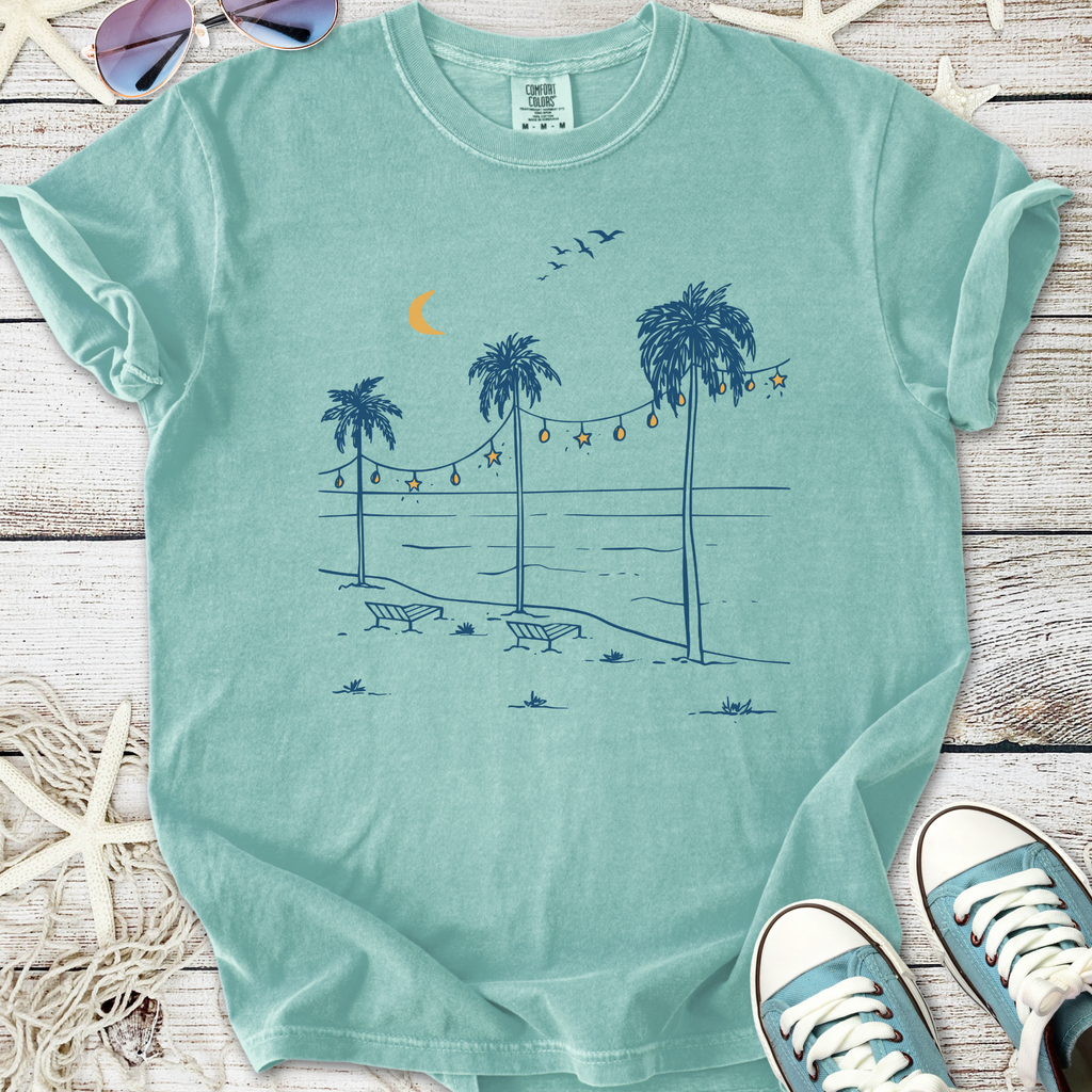 Mint green graphic t-shirt featuring beach scene with palm trees and chairs, perfect for casual summer wear.