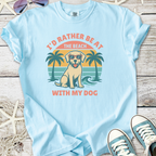 Light blue t-shirt featuring a dog with sunglasses and palm trees, perfect for dog lovers.