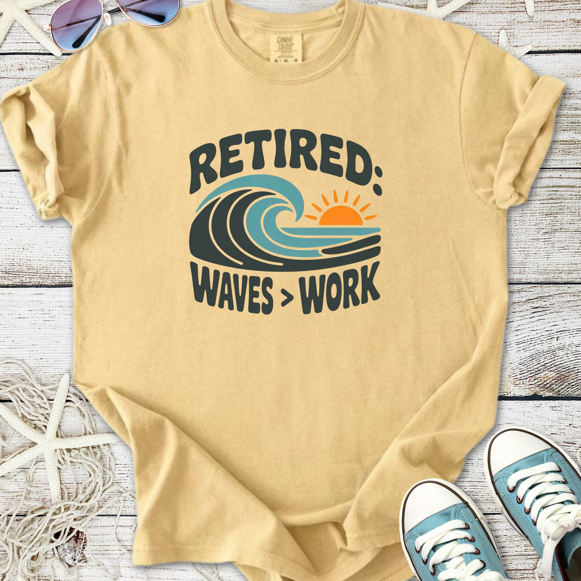 Beige retired graphic t-shirt featuring waves and sun design, perfect for beach lovers.