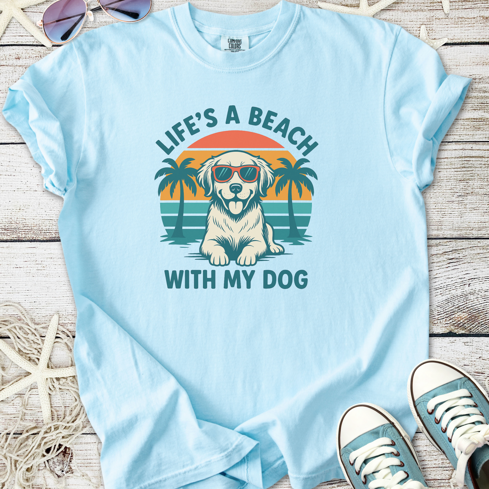 Blue graphic t-shirt featuring a dog in sunglasses with palm trees, perfect for summer and dog lovers.