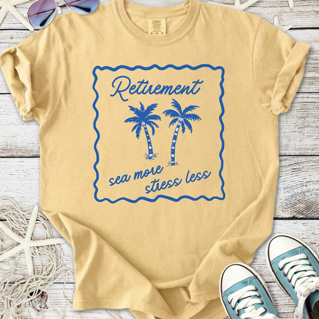 Light yellow retirement t-shirt with blue palm tree graphic and slogan 'sea more stress less'.