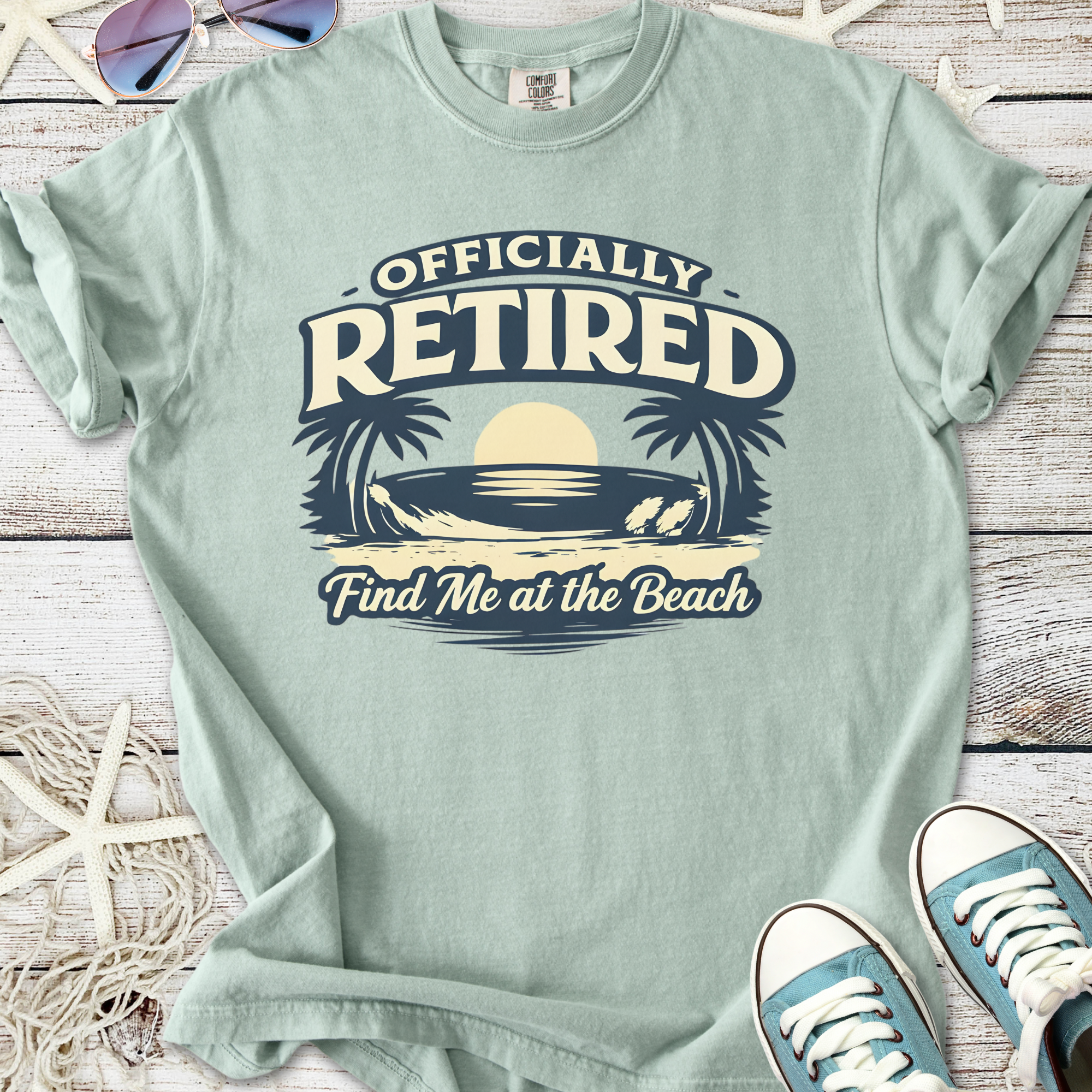 Mint green t-shirt with 'Officially Retired' graphic and beach theme, perfect for relaxed casual wear.