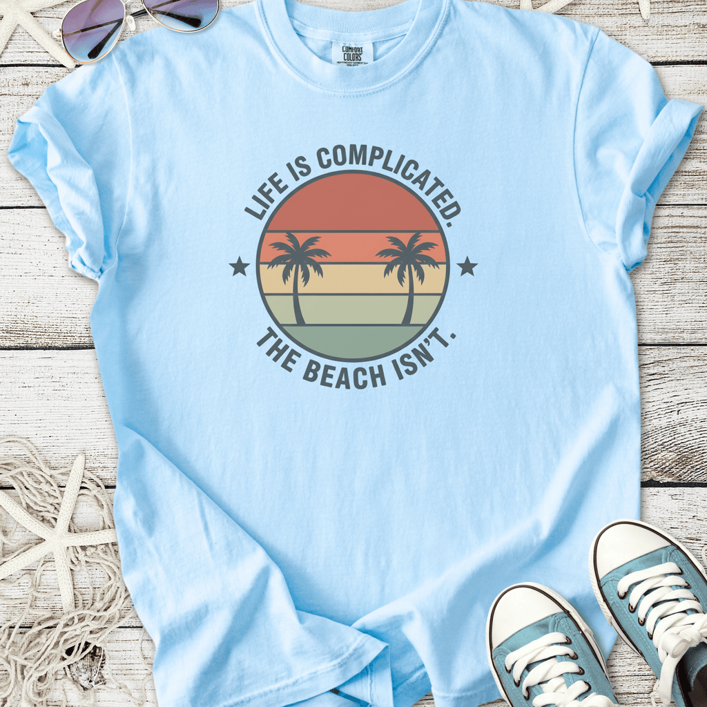 Light blue t-shirt with 'Life is Complicated. The Beach Isn't.' design and palm trees.