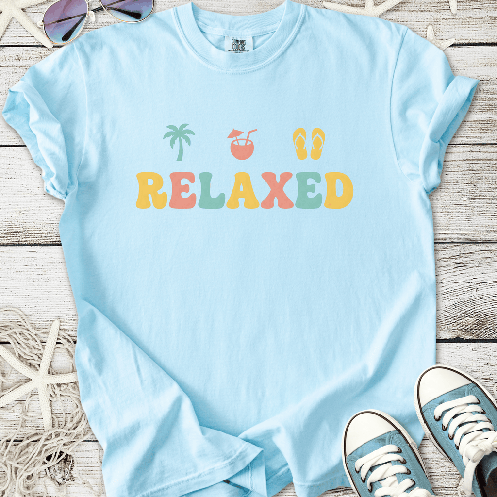Light blue relaxed fit t-shirt with colorful beach-themed design and soft cotton material.