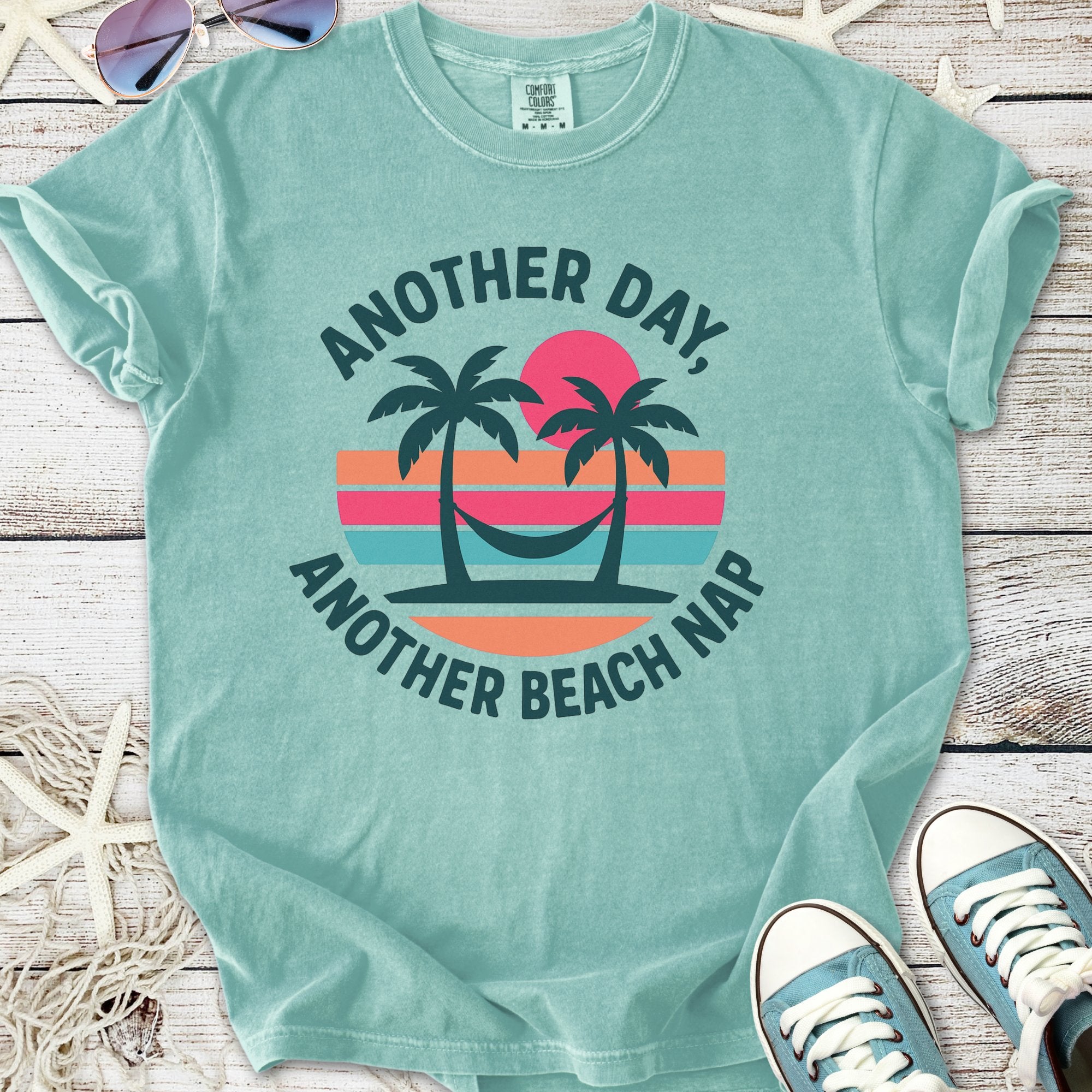 Mint green t-shirt featuring palm tree graphic and 'Another Day, Another Beach Nap' slogan.