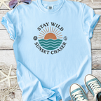 Light blue cotton t-shirt with 'Stay Wild Sunset Chaser' graphic featuring a sunset and waves.