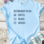 Light blue t-shirt with 'Retirement Plan: Coffee. Beach. Repeat' printed design, ideal for casual wear.