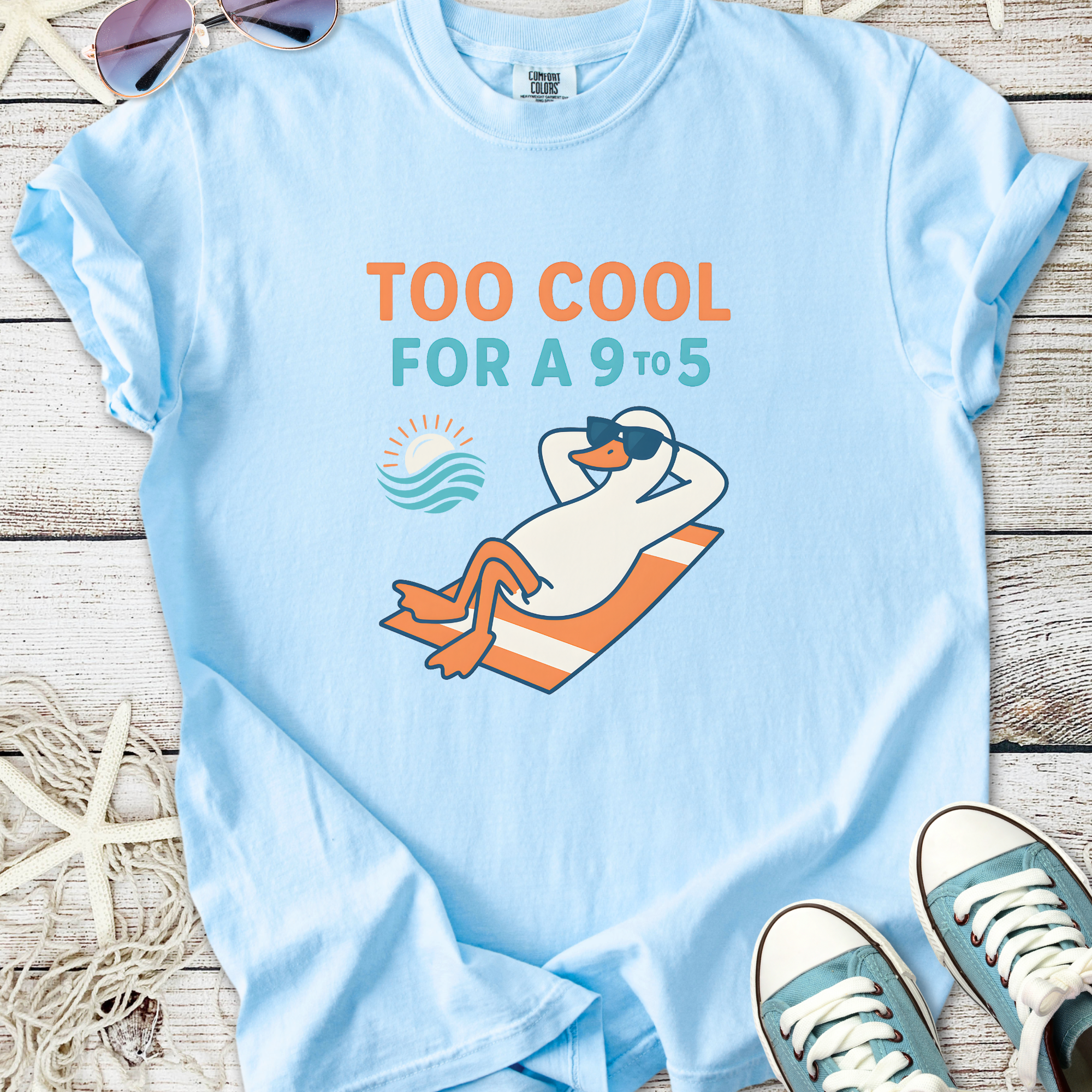 Light blue t-shirt featuring a cool duck lounging with sunglasses, perfect for casual summer wear.