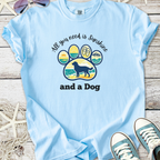 Light blue t-shirt with dog paw graphic and 'All you need is sunshine and a Dog' text, made of soft cotton.