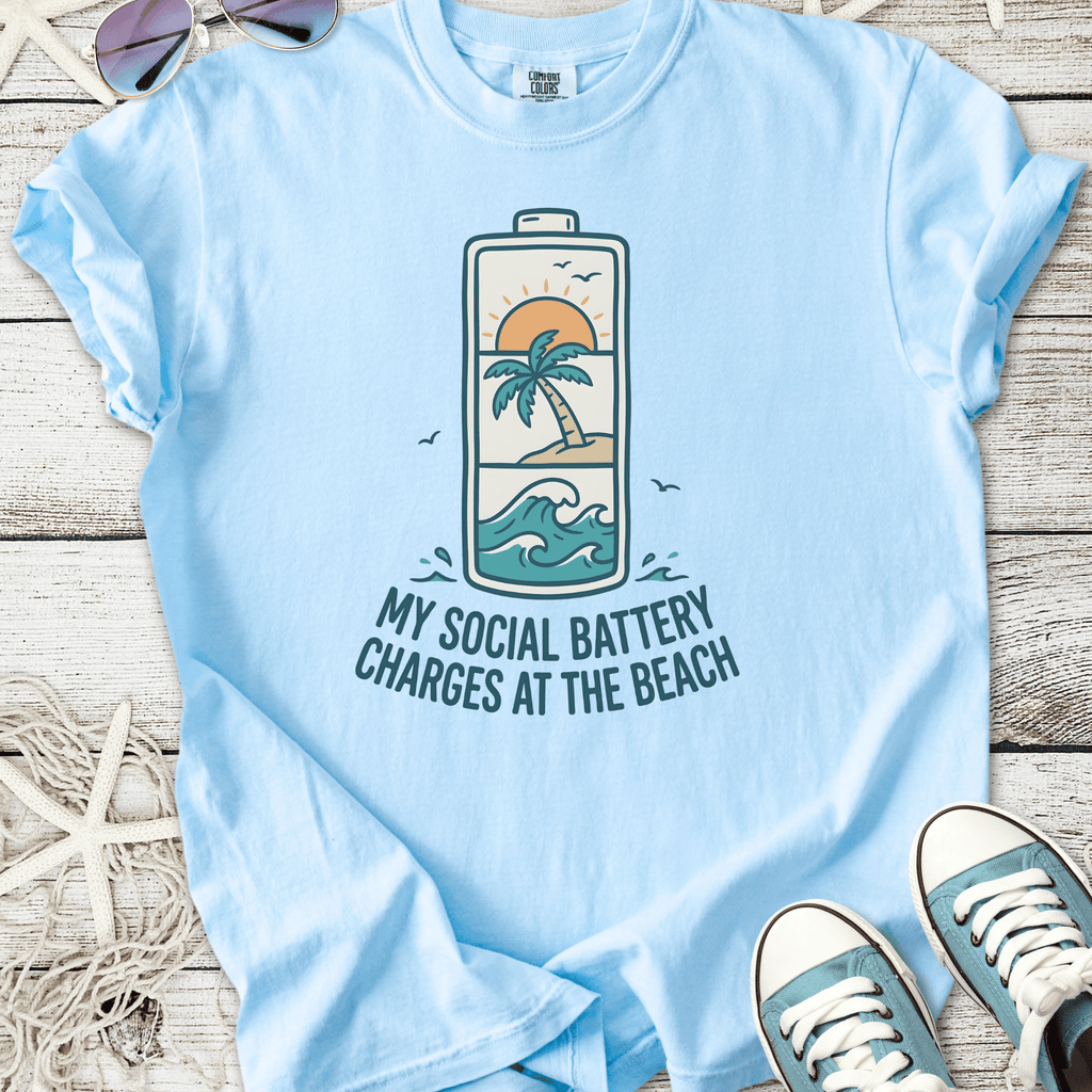 Light blue t-shirt with beach-themed graphic, 'My Social Battery Charges at the Beach' text.
