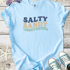 Light blue unisex t-shirt featuring 'Salty Sandy Unbothered' text in colorful lettering.
