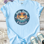 Light blue t-shirt with 'Salty, Sandy & Retired' graphic design featuring palm trees and ocean waves.