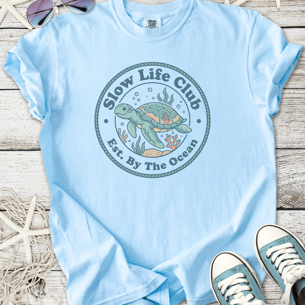 Light blue t-shirt with 'Slow Life Club' sea turtle graphic, perfect for ocean lovers.