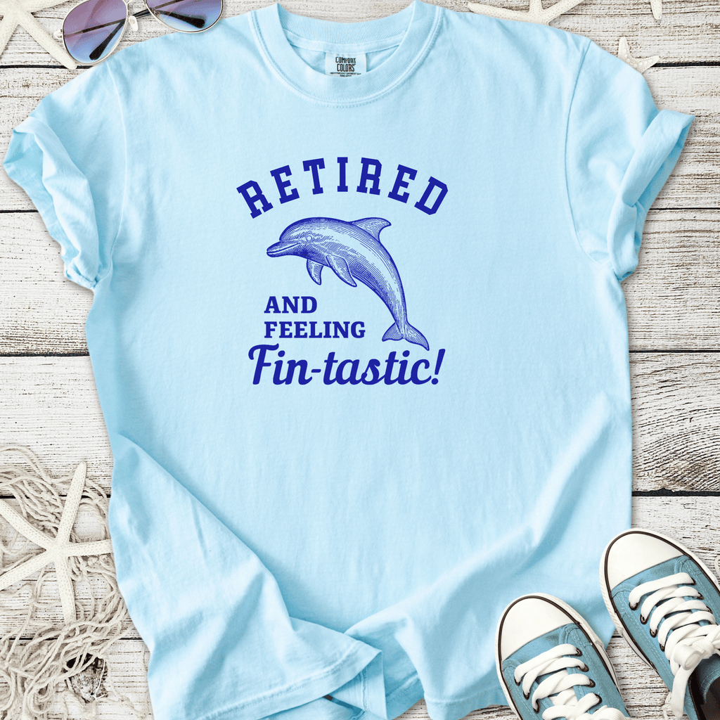Light blue t-shirt featuring dolphin graphic and 'Retired and Feeling Fin-tastic!' text.