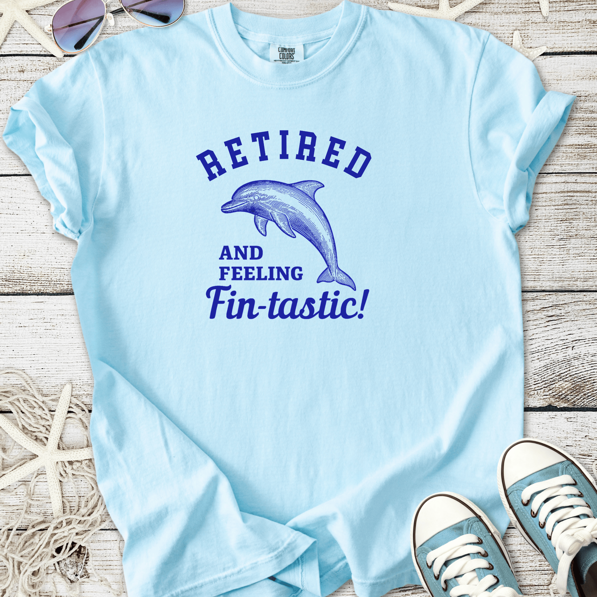 Light blue t-shirt featuring dolphin graphic and 'Retired and Feeling Fin-tastic!' text.