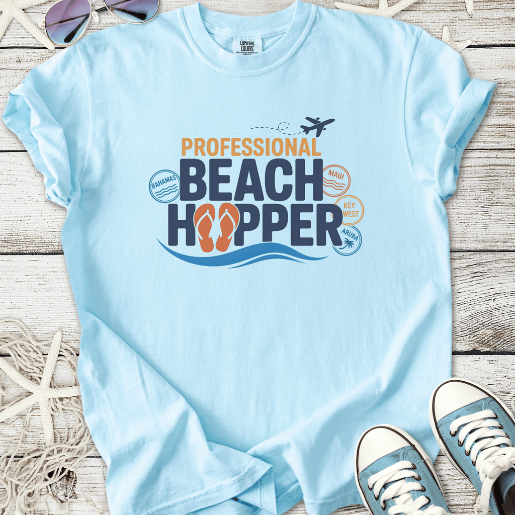Light blue t-shirt featuring 'Professional Beach Hopper' graphic with flip-flops, ideal for beach lovers.