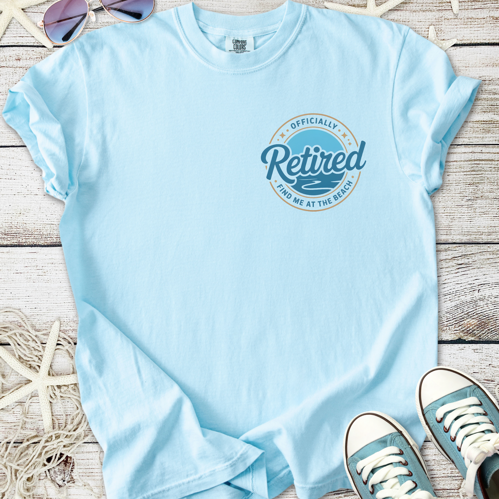 Light blue t-shirt with 'Officially Retired' graphic, perfect for beach lovers. Comfortable cotton material.