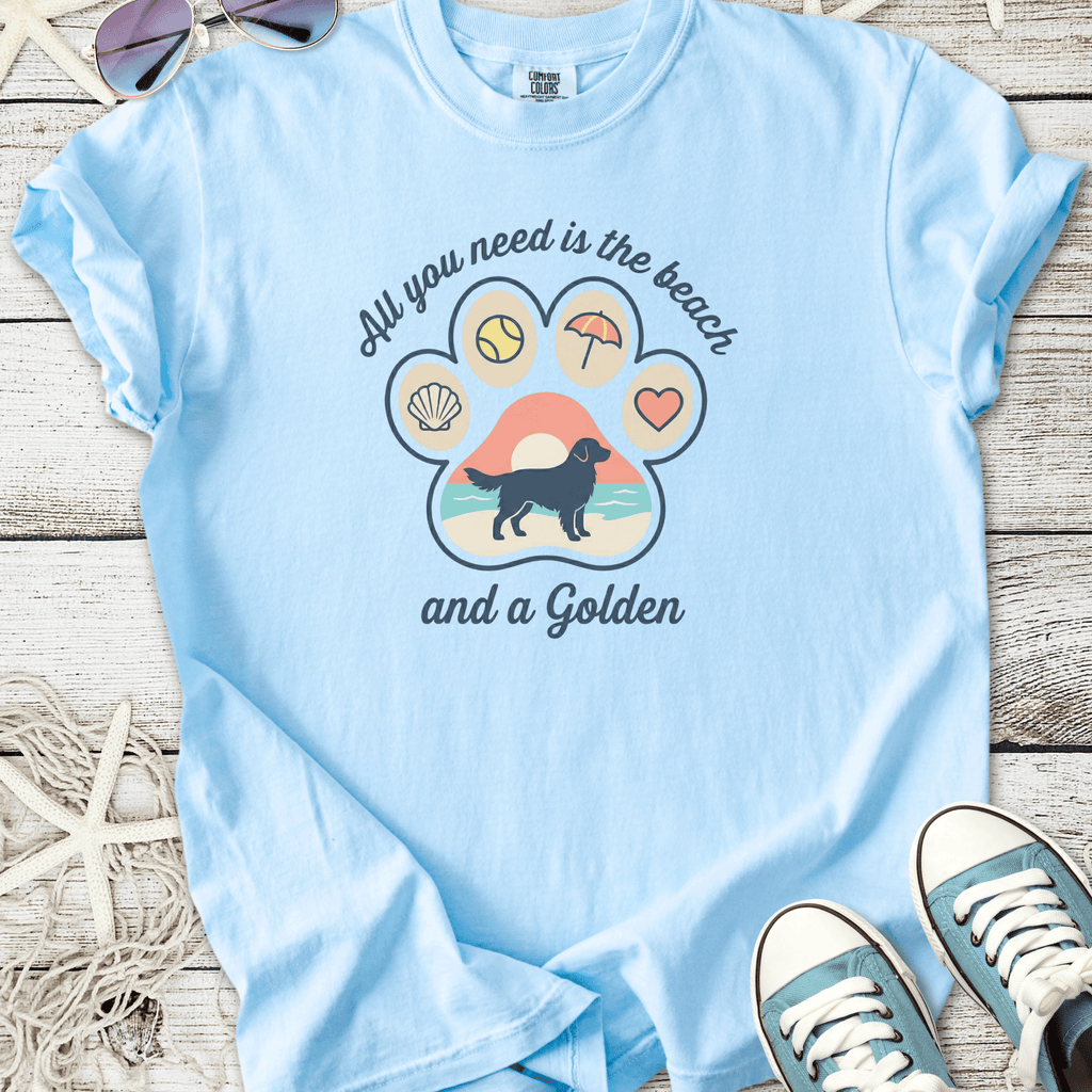 Light blue t-shirt featuring a paw graphic with beach-themed designs and text about Golden Retrievers.
