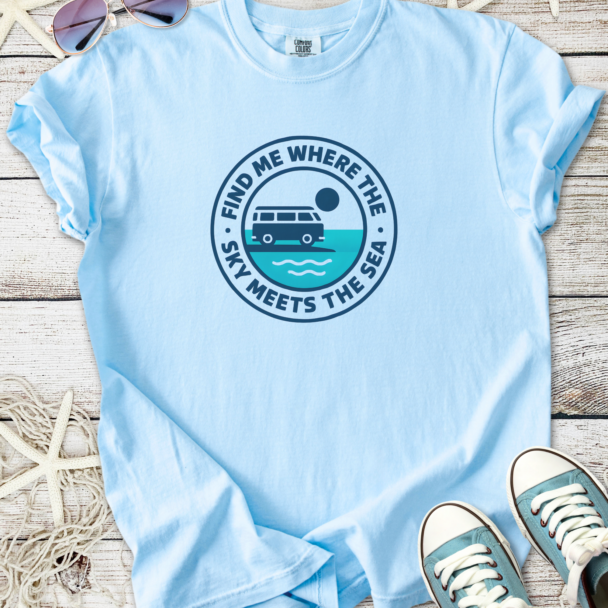 Light blue t-shirt with 'Find Me Where the Sky Meets the Sea' graphic, featuring a vintage van and waves.