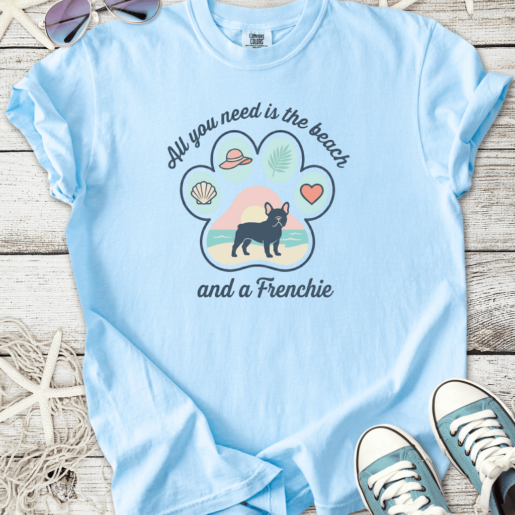 Light blue t-shirt featuring a cute Frenchie graphic with beach themes and the text 'All you need is the beach'.