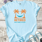 Light blue cotton t-shirt with 'Retired Sun, Sand & Sleep' graphic, featuring palm trees and a hammock.