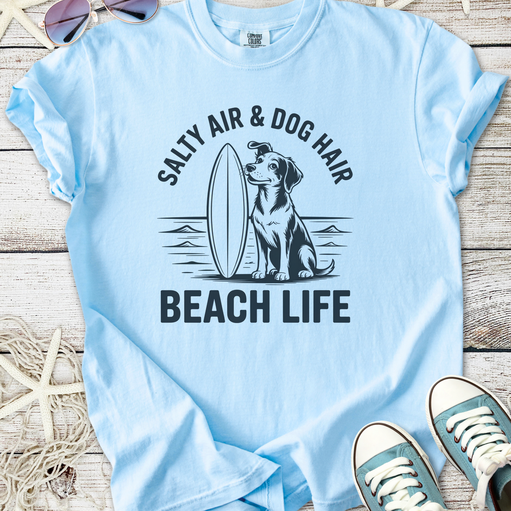 Light blue t-shirt with dog graphic and 'Salty Air & Dog Hair Beach Life' slogan, perfect for beach lovers.