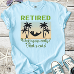 Light blue retired t-shirt with hammock and palm tree design, humorous text about waking up early.