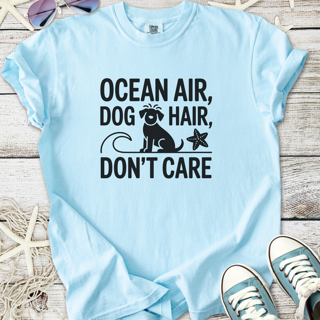 Light blue cotton t-shirt with 'Ocean Air, Dog Hair, Don’t Care' graphic for beach lovers.