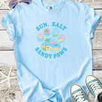 Light blue t-shirt with 'Sun, Salt, Sandy Paws' graphic, featuring beach and palm tree design.