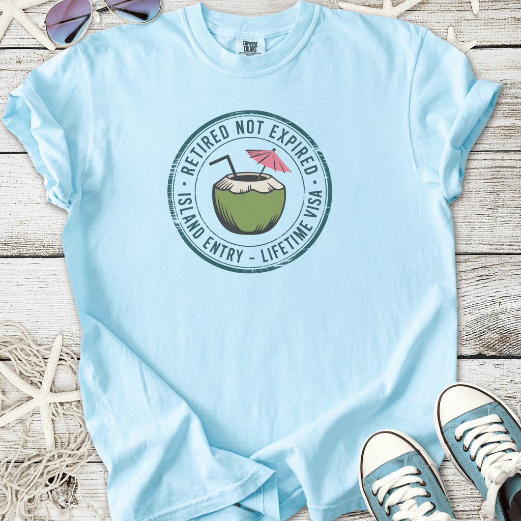 Light blue t-shirt with 'Retired Not Expired' coconut graphic, perfect for casual, island-themed wear.