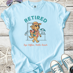 Light blue t-shirt featuring a cartoon dog in sunglasses, promoting a 'Retired' beach lifestyle.