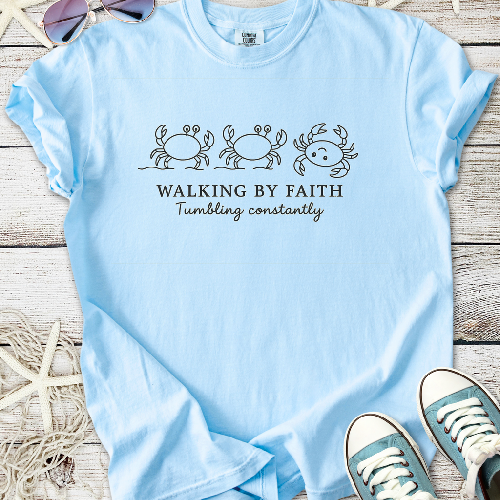 Light blue t-shirt with crab design and text 'Walking by Faith, Tumbling constantly', made from soft cotton.