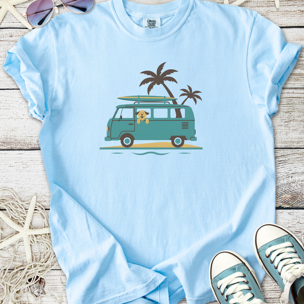 Light blue t-shirt featuring a vintage surf van graphic with palm trees and a playful dog.