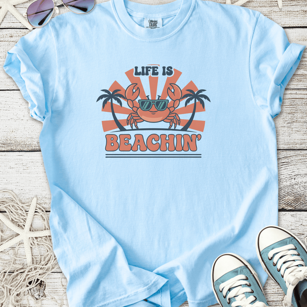 Light blue t-shirt with 'Life is Beachin'' graphic featuring a crab and palm trees, ideal for summer.