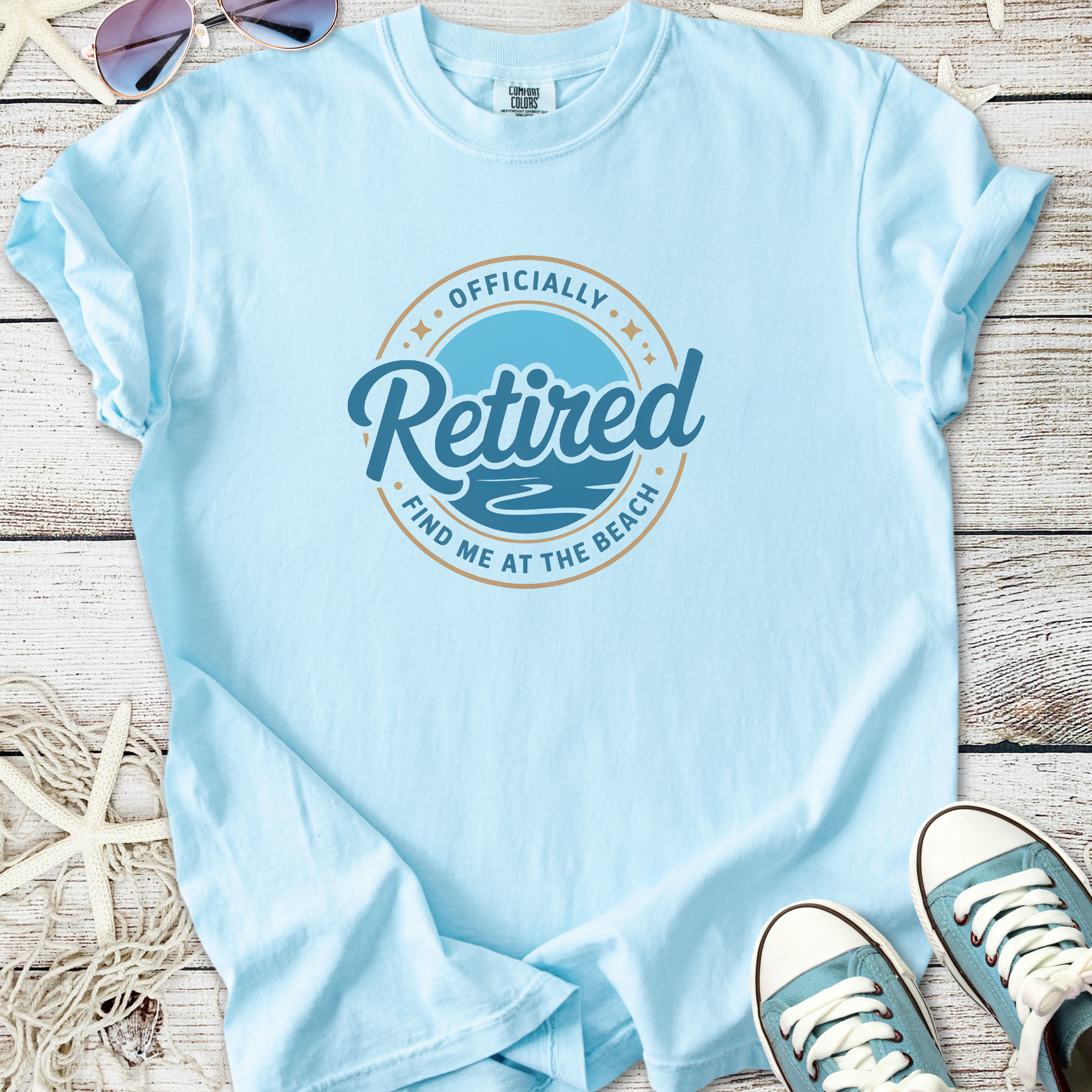 Light blue retired t-shirt with beach-themed graphic, perfect for relaxed outings.