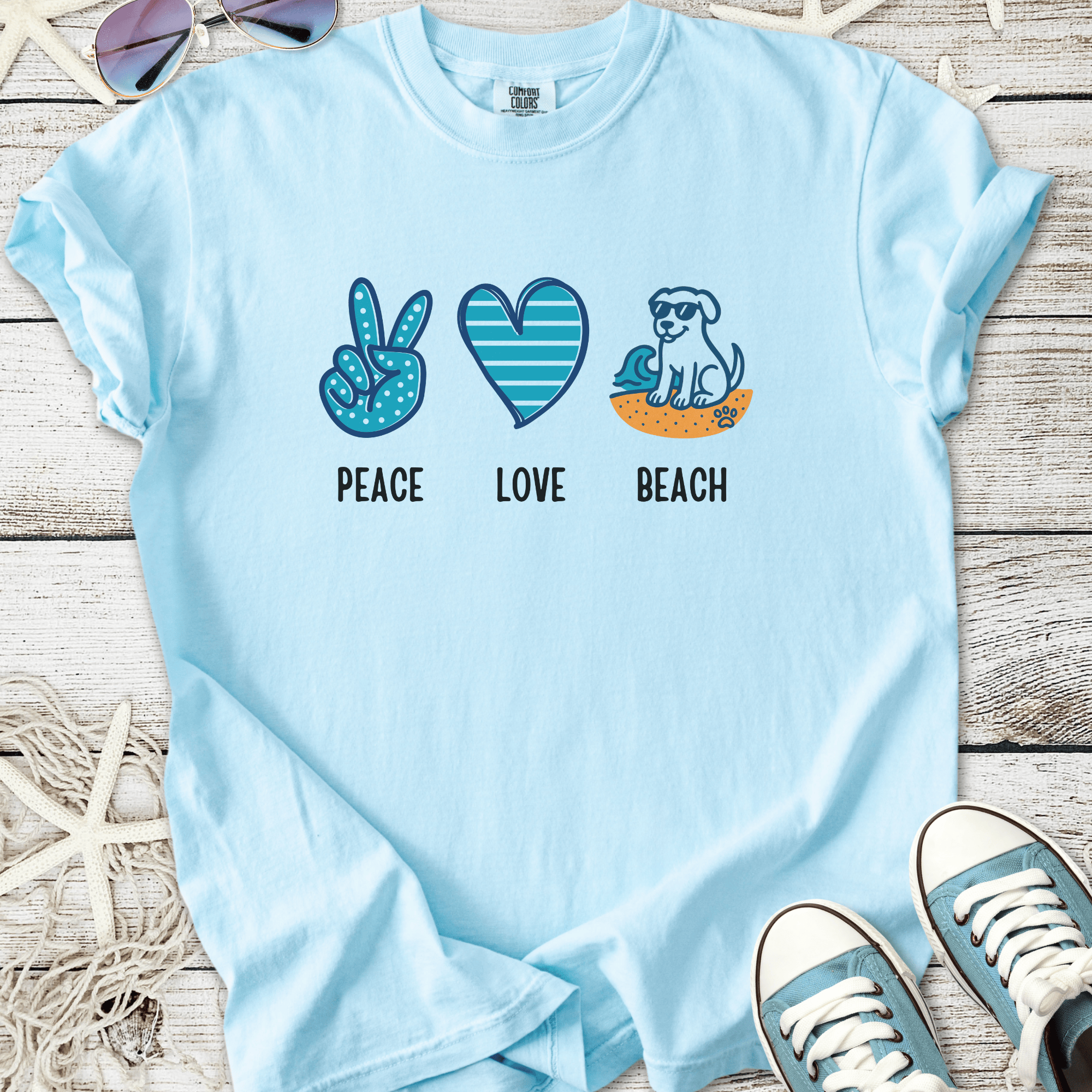 Light blue cotton t-shirt featuring 'Peace Love Beach' graphic with dog, beach symbols.