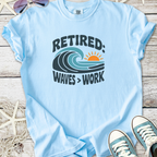 Light blue retired graphic t-shirt featuring waves and sun design, perfect for casual wear.
