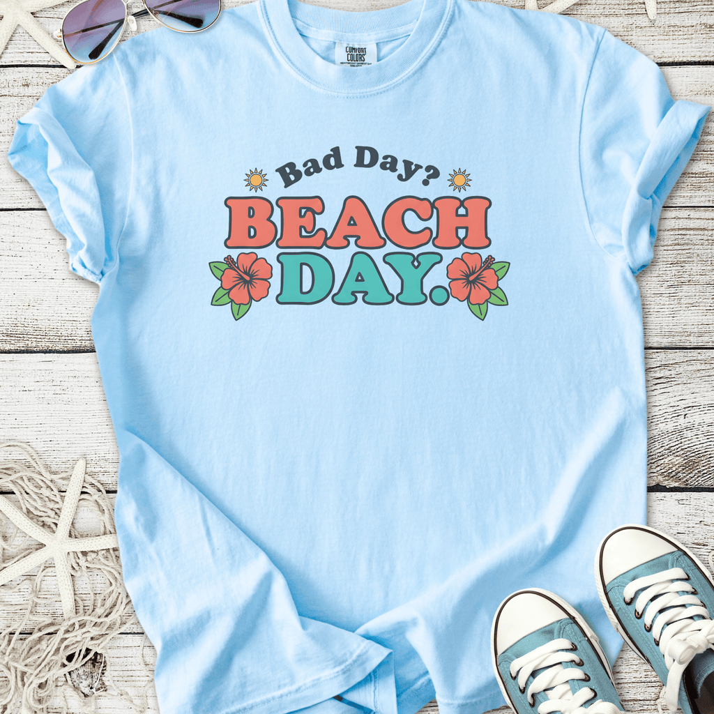 Light blue graphic tee with 'Bad Day? BEACH DAY!' text and floral design, perfect for summer outings.