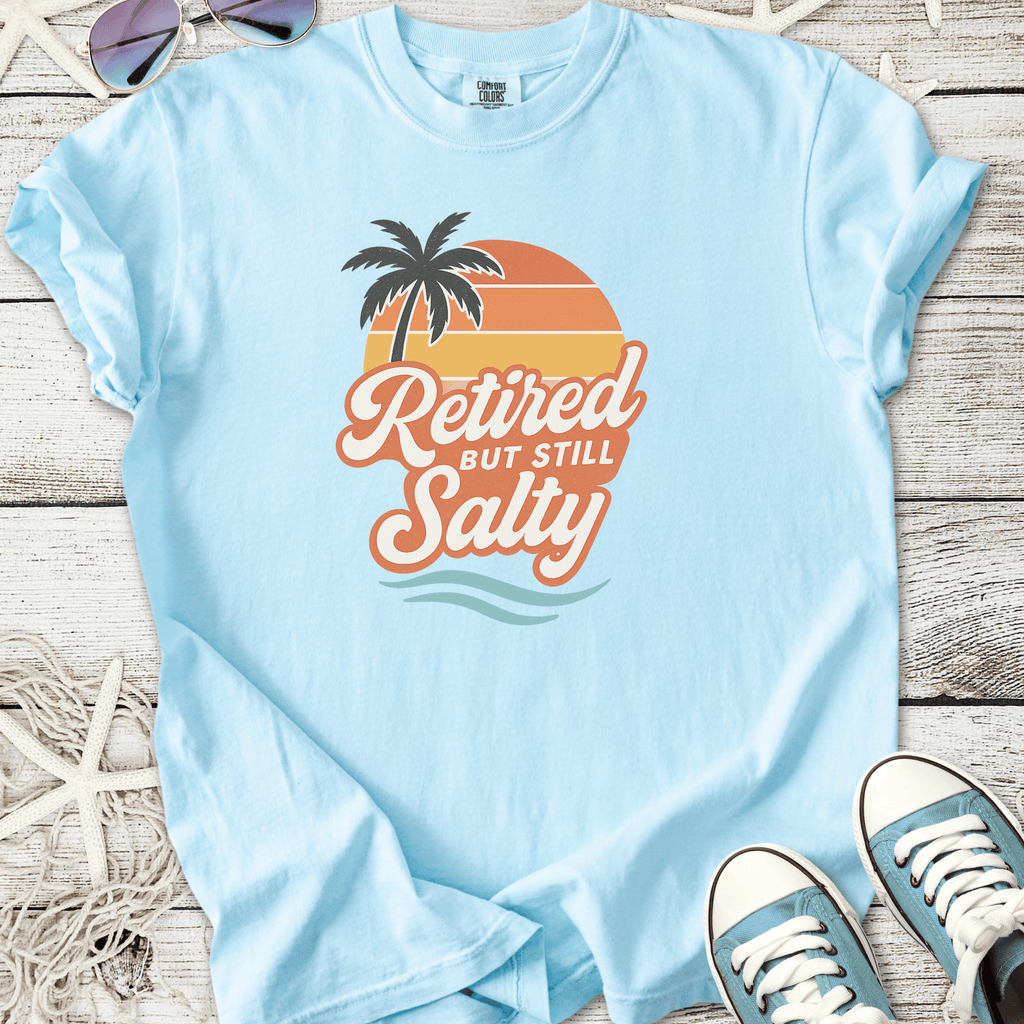 Light blue t-shirt with 'Retired But Still Salty' graphic, featuring palm tree and sunset design.