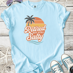 Light blue t-shirt with 'Retired But Still Salty' graphic, featuring palm tree and sunset design.